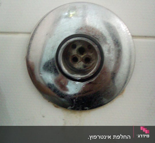 ניקוז מתכת עגול עם חורים בכיור